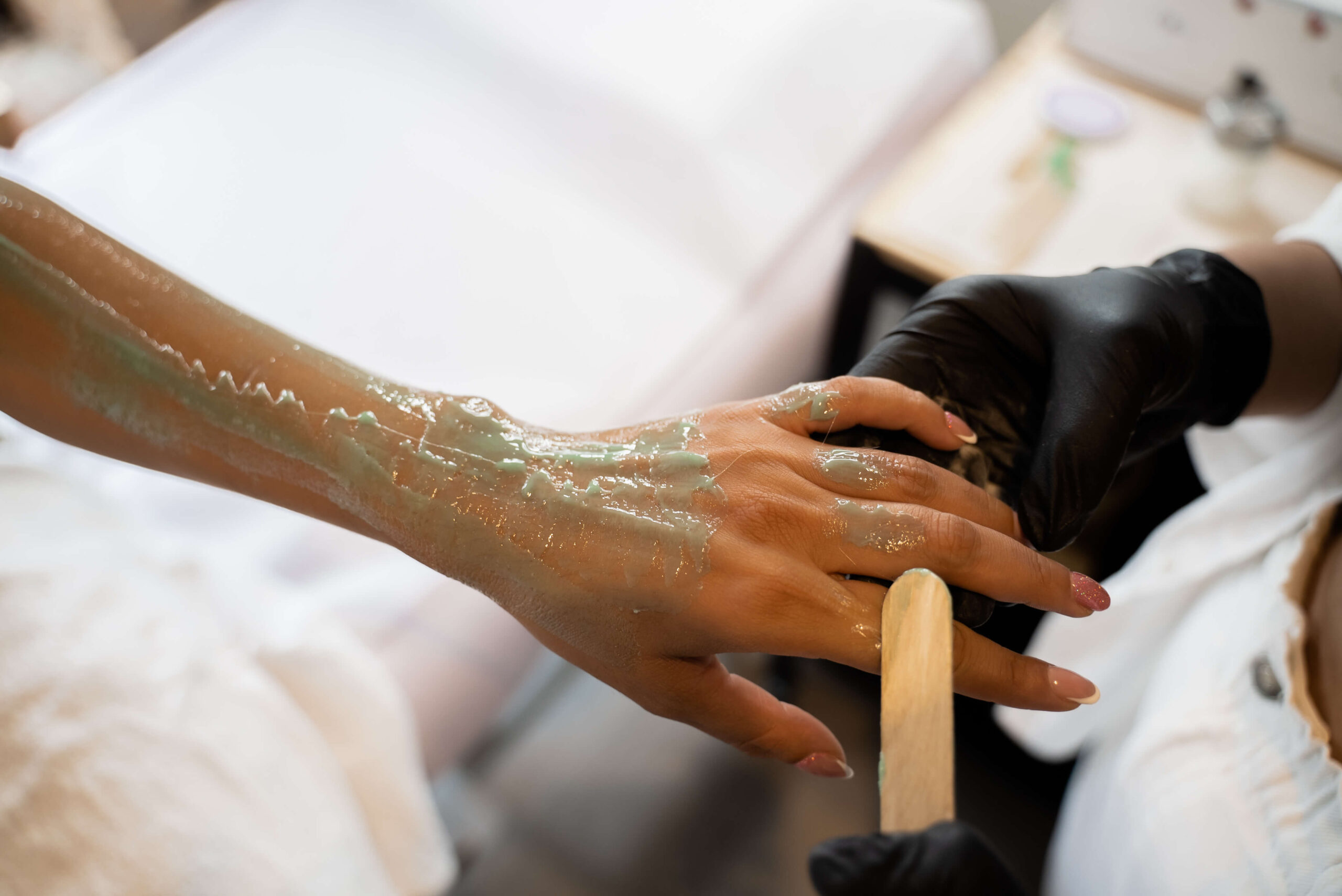 A woman is getting her hands painted with green paint.