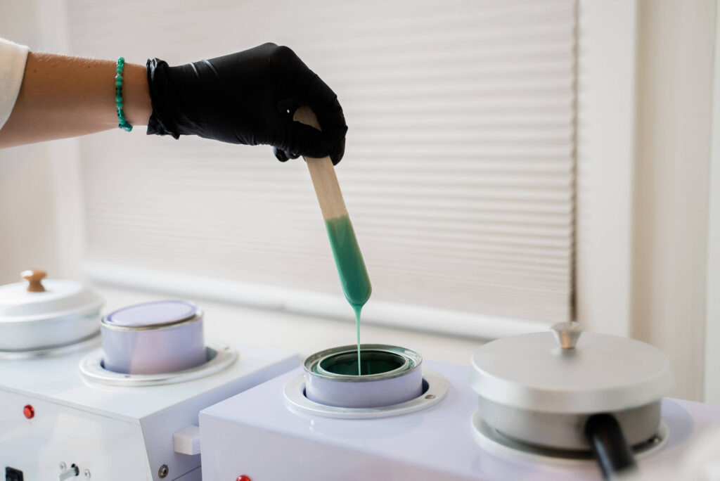 A person is pouring green liquid into a container.