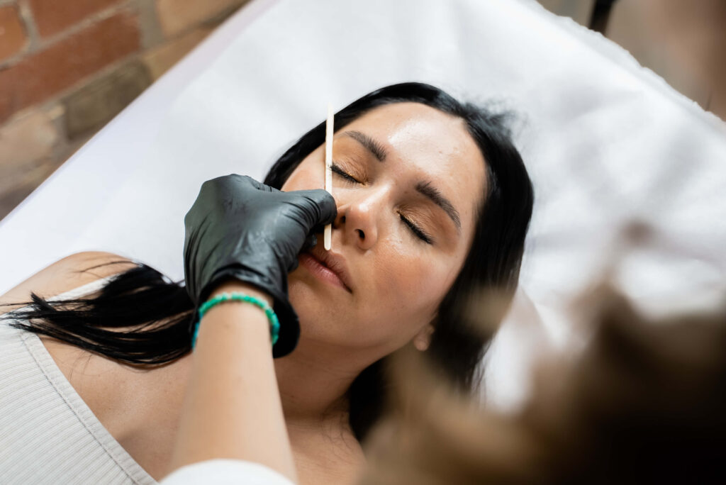 A woman getting her eyebrows done in a hospital.